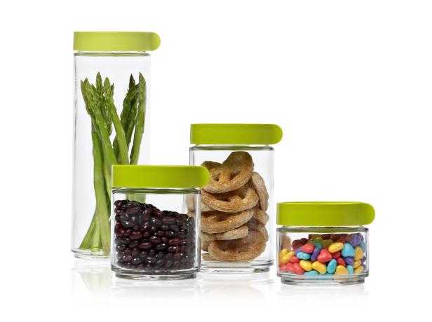 Vier Glasbehälter mit grünem Deckel, gefüllt mit Spargel, Bohnen, Brezeln und Süßigkeiten.