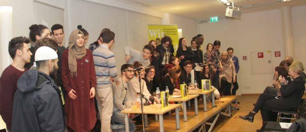 Eine Gruppe junger Menschen steht auf einer Bühne vor einem Publikum.