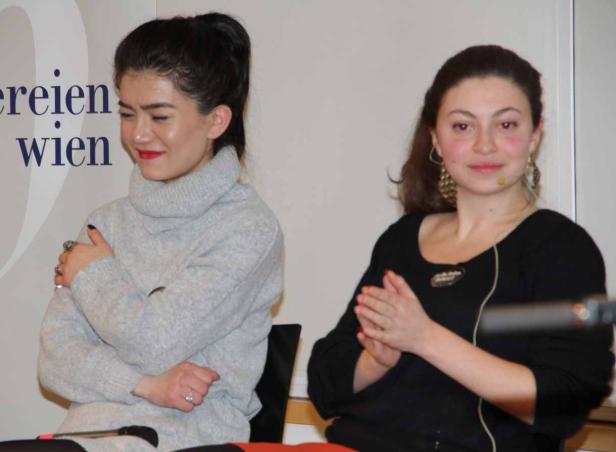 Zwei Frauen sitzen nebeneinander bei einer Veranstaltung.