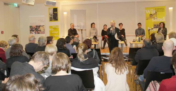 Eine Frau spricht bei einer Podiumsdiskussion vor Publikum in Wien.