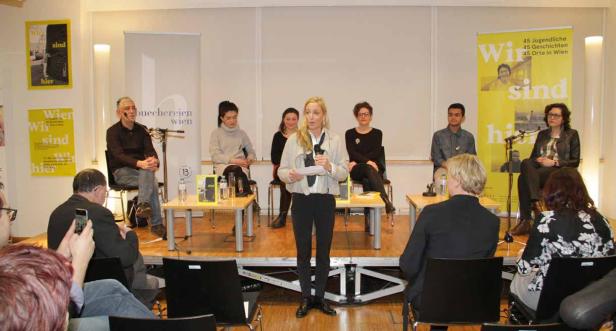 Eine Frau spricht bei einer Podiumsdiskussion zum Thema „Wir sind hier“ in Wien.