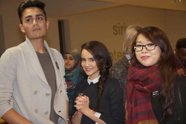 Eine Gruppe junger Menschen unterschiedlicher Herkunft steht zusammen.