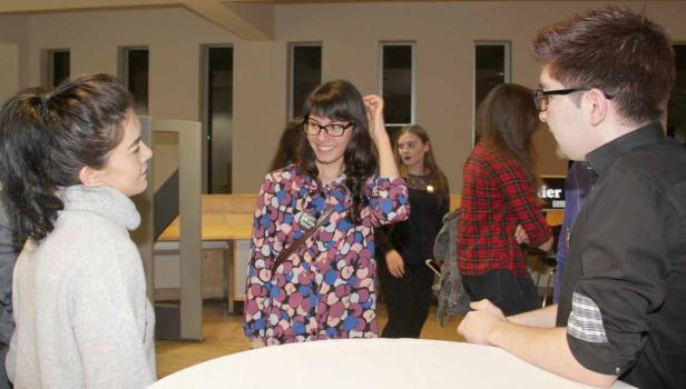 Mehrere Personen unterhalten sich in einem Raum während einer Veranstaltung.