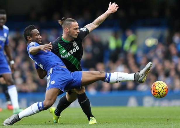 Zwei Fußballspieler kämpfen um den Ball auf dem Spielfeld.
