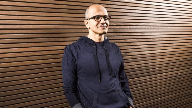 Satya Nadella Satya Nadella, der CEO von Microsoft, posiert vor einer Holzwand.