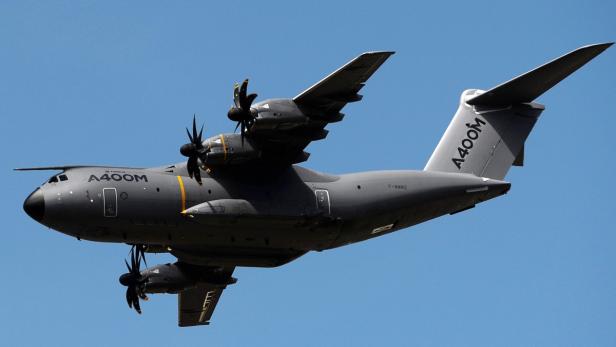Ein Airbus A400M Militärtransporter im Flug vor blauem Himmel.