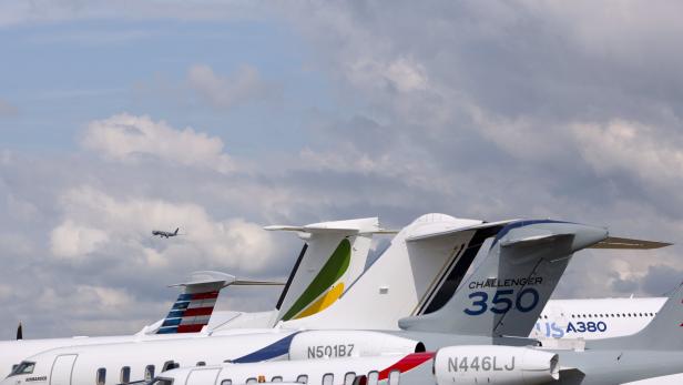 Mehrere Flugzeuge unterschiedlicher Bauart stehen auf einem Flugplatz.