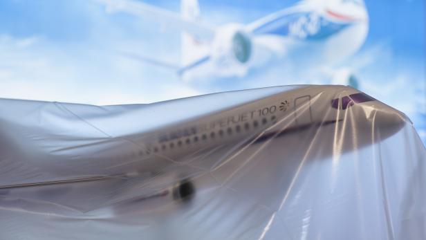 Ein Sukhoi Superjet 100 Modell ist mit Plastik abgedeckt.