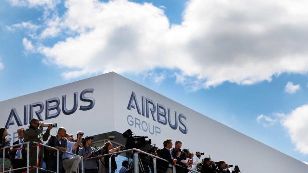 Journalisten und Fotografen vor dem Airbus Group Logo.