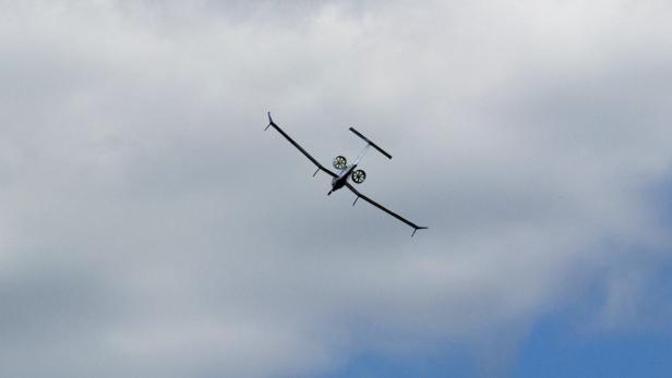 Ein Flugzeug mit Propellern fliegt vor einem bewölkten Himmel.