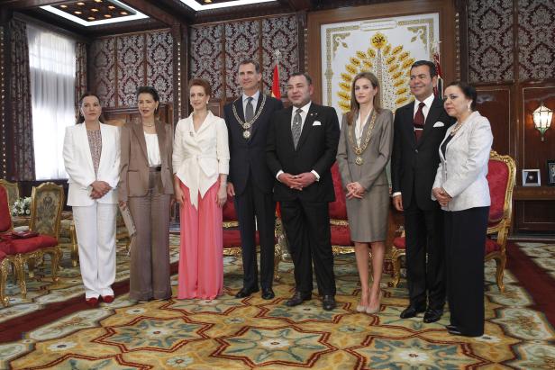 Eine Gruppe von Würdenträgern posiert in einem opulenten Raum für ein Foto.