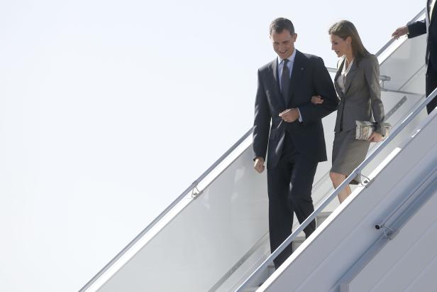 König Felipe und Königin Letizia steigen eine Flugzeugtreppe hinunter.