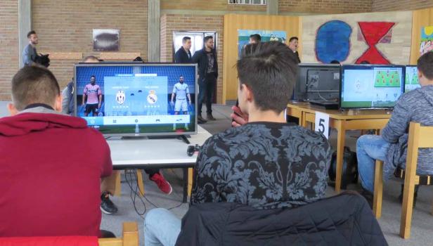 Mehrere Personen spielen ein Fußball-Videospiel auf Bildschirmen.