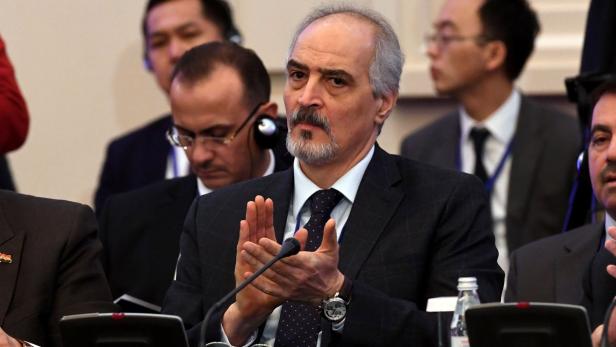 Ein Mann mit Bart klatscht bei einer Konferenz in die Hände.