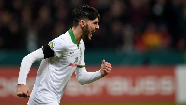 Ein jubelnder Fußballspieler im Trikot von Werder Bremen.