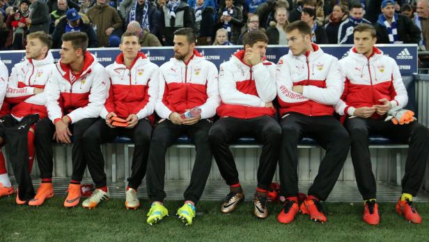 Mehrere Fußballspieler des VfB Stuttgart sitzen auf der Bank.