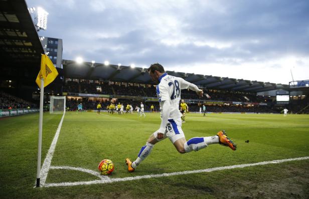 Ein Fußballspieler schießt den Ball von der Eckfahne aus.