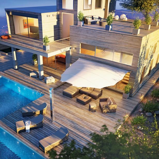 Ein modernes Holzhaus mit Pool und Terrasse bei Dämmerung.
