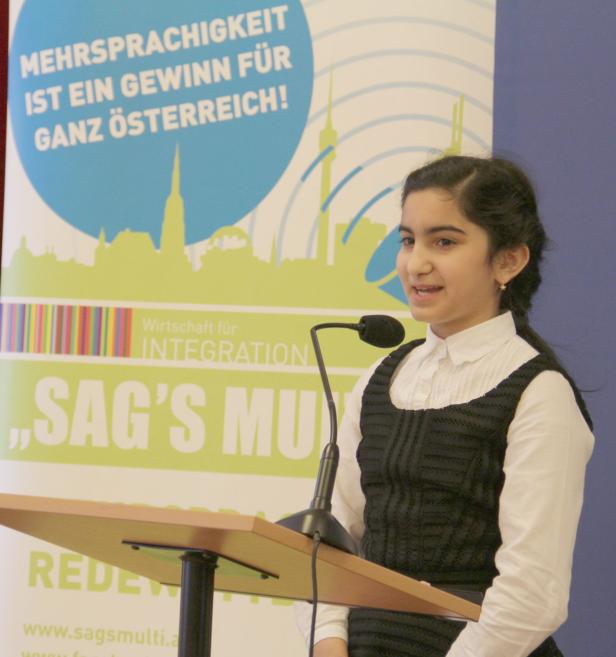 Ein junges Mädchen hält eine Rede bei einer Veranstaltung von „Wirtschaft für Integration“.