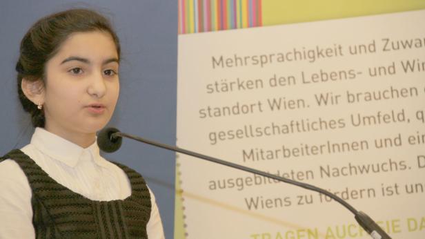 Ein junges Mädchen spricht bei einer Veranstaltung in ein Mikrofon.