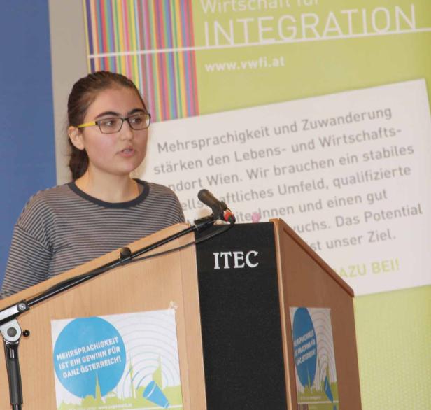 Eine junge Frau spricht an einem Rednerpult mit der Aufschrift „ITEC“.