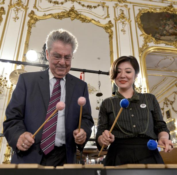 Ein Mann und eine Frau spielen Xylophon in einem prunkvollen Raum.