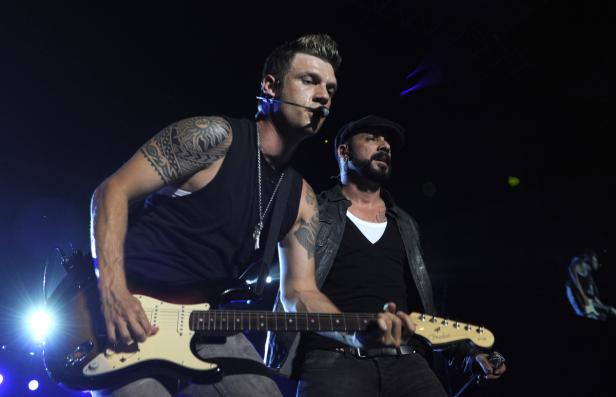 Nick Carter und A. J. McLean von den Backstreet Boys spielen Gitarre auf der Bühne.