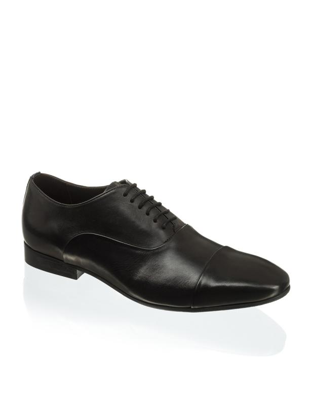 Ein einzelner, schwarzer Lederschuh mit Schnürsenkeln steht auf einem weißen Hintergrund.