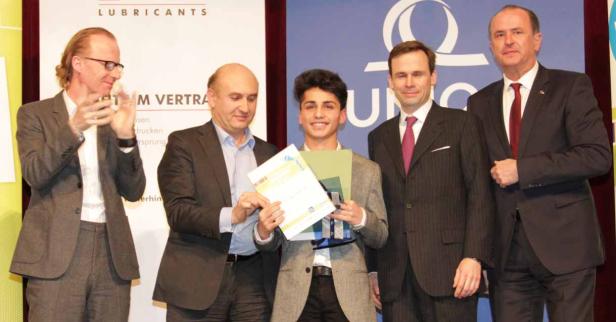 Ein junger Mann wird von vier Personen für seine Leistung geehrt.