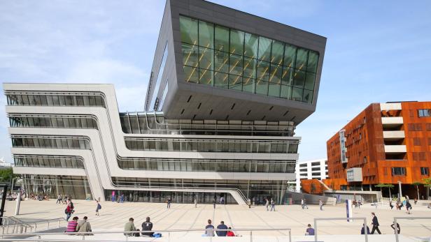 Die Wirtschaftsuniversität Wien mit Passanten auf dem Vorplatz.