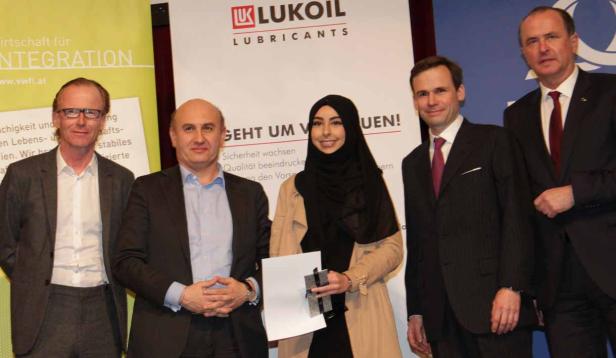 Eine Gruppe von Personen posiert vor einem Banner von Lukoil Lubricants.