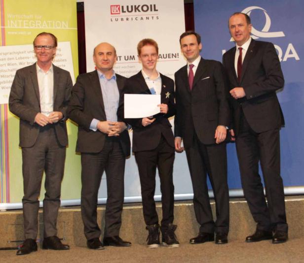 Fünf Männer in Anzügen posieren auf einer Bühne vor einem Banner von Lukoil.