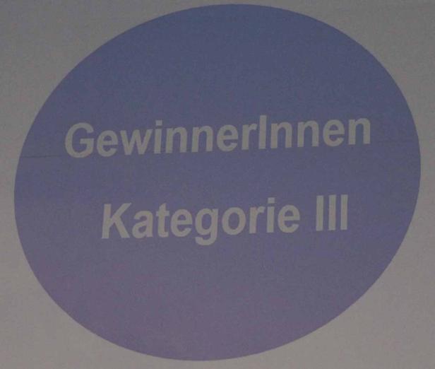 „GewinnerInnen Kategorie III“ steht auf einem lila Kreis.