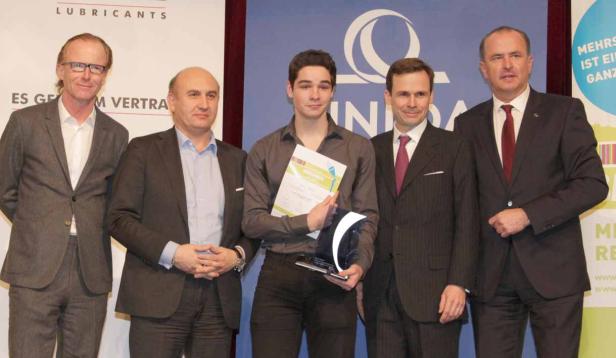 Eine Gruppe von fünf Männern posiert für ein Foto mit einer Urkunde und einer Auszeichnung.