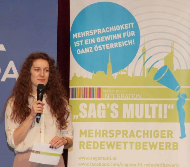Eine Frau spricht bei einem „Sag's Multi!“ Redewettbewerb.