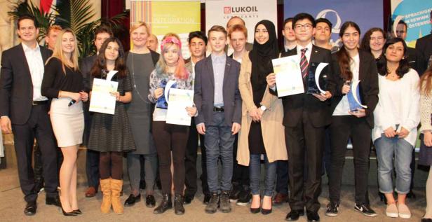 Eine Gruppe junger Menschen posiert mit Urkunden und Auszeichnungen für ein Foto.