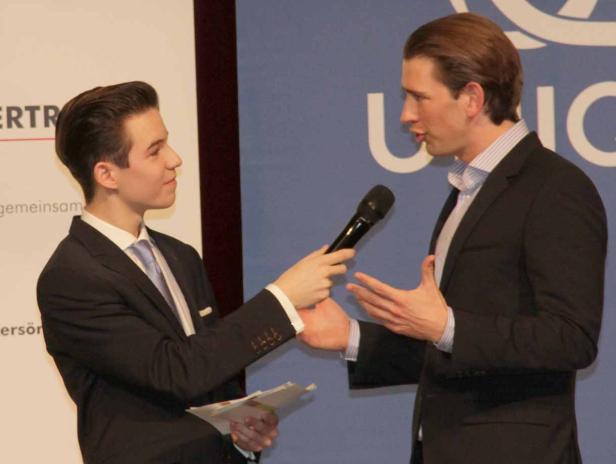 Ein junger Mann interviewt eine andere Person mit einem Mikrofon.