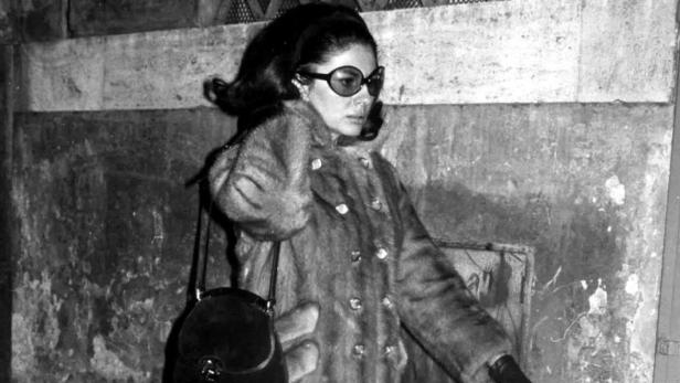 Eine Frau mit Sonnenbrille und Pelzmantel in einer Schwarzweißaufnahme.