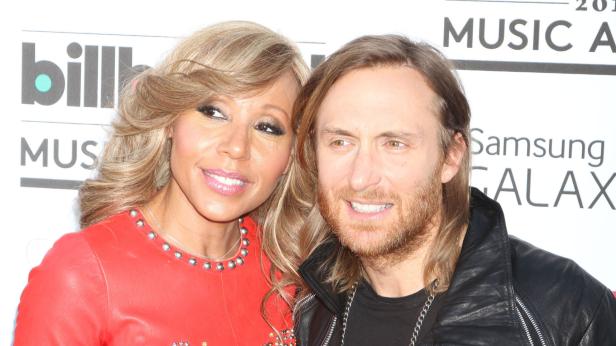David Guetta posiert mit einer Frau auf dem roten Teppich.