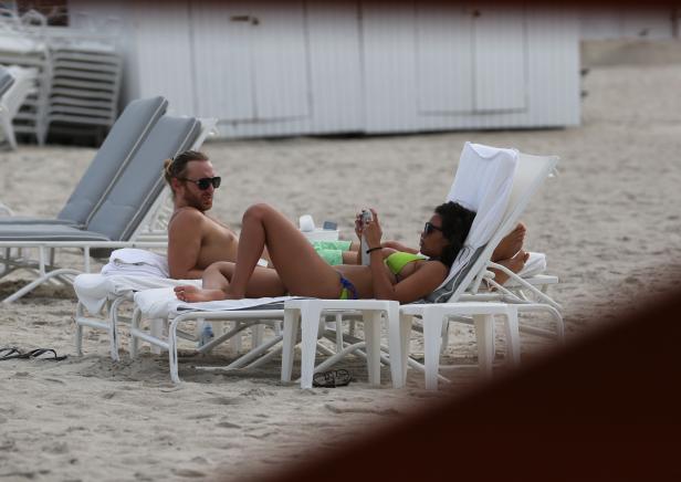Ein Paar entspannt sich am Strand auf Liegestühlen.