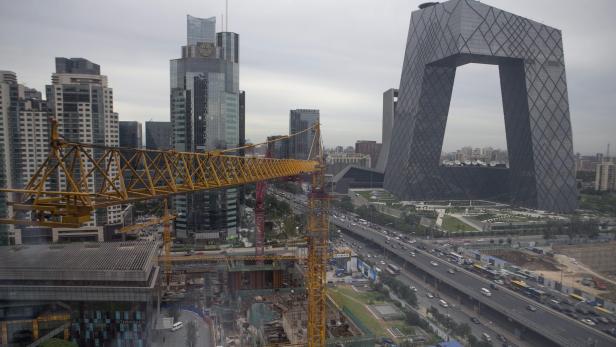 Blick auf Peking mit dem CCTV-Hauptgebäude und einer Baustelle im Vordergrund.