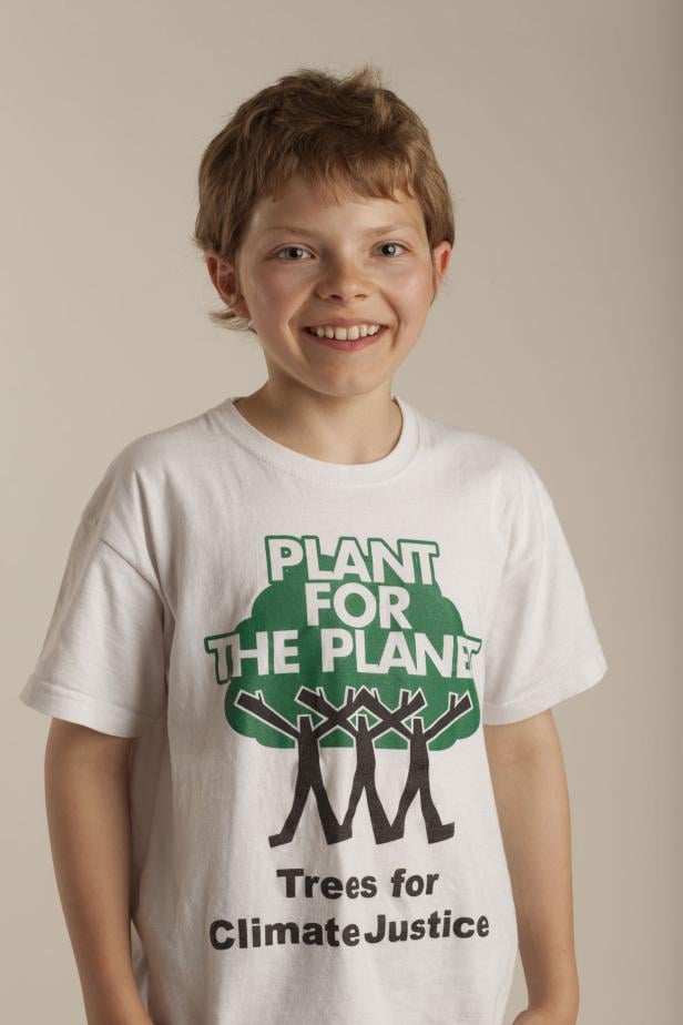 Ein lächelnder Junge trägt ein T-Shirt mit der Aufschrift „Plant for the Planet“.