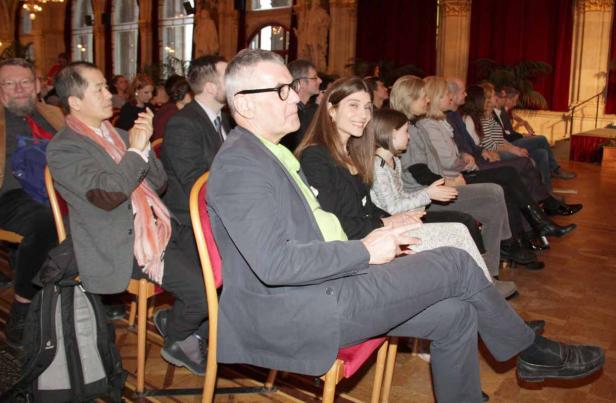 Zuschauer sitzen bei einer Veranstaltung in einem Saal.