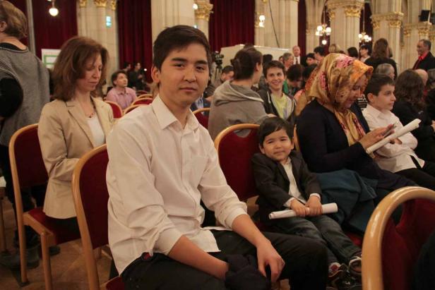 Menschen sitzen in einem Saal während einer Veranstaltung.