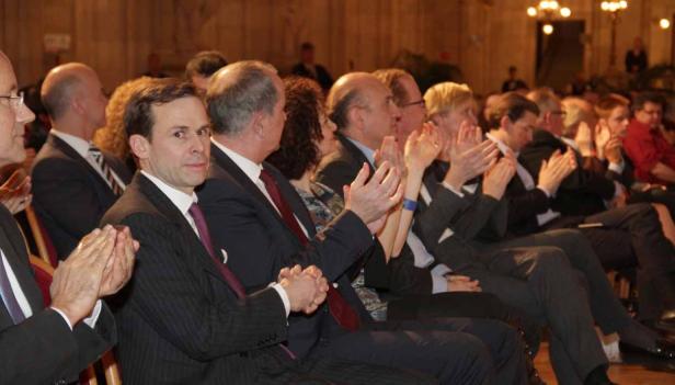 Zuschauer applaudieren während einer Veranstaltung in einem festlichen Saal.