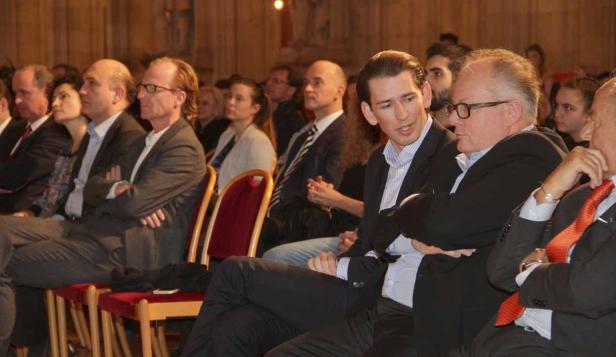 Sebastian Kurz sitzt mit anderen Personen bei einer Veranstaltung.