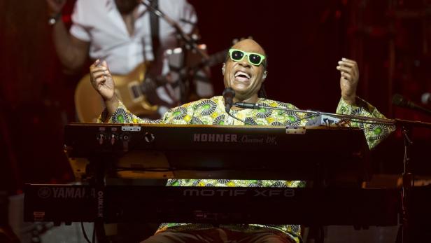 Stevie Wonder spielt auf der Bühne Keyboard und singt.