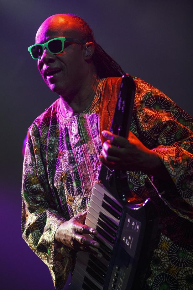 Stevie Wonder spielt auf der Bühne einen tragbaren Synthesizer.