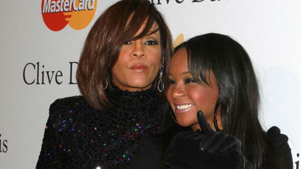 Bobby Brown Whitney Houston und Bobbi Kristina posieren zusammen auf einer Veranstaltung.