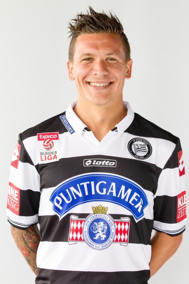 Ein lächelnder Fußballspieler im Trikot des SK Sturm Graz.